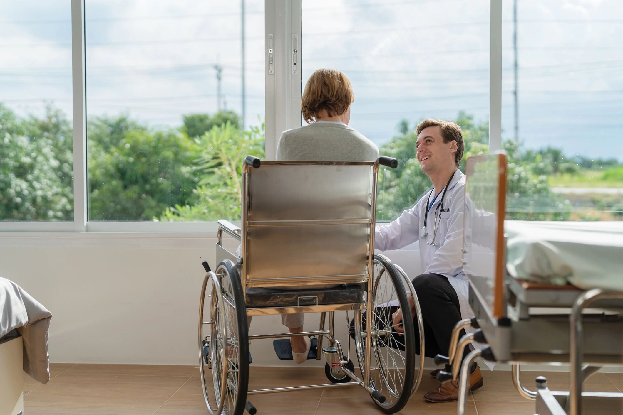 Doctor supporting an elderly woman in a wheelchair